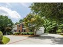 Brick home with a lovely front porch and a long, paved driveway flanked by lush greenery and mature trees at 4047 Dunwoody Club Dr, Dunwoody, GA 30350