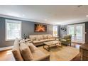 Bright living room featuring neutral furniture, wood floors, two windows, and a decorative piece of art at 4047 Dunwoody Club Dr, Dunwoody, GA 30350