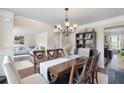 Spacious dining room with a wooden table set, a chandelier, and views into the living areas at 4455 Orchard Lake Dr, Cumming, GA 30028
