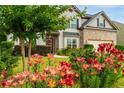 Well landscaped home exterior with a variety of flowers and healthy green lawn leading to the front door at 4455 Orchard Lake Dr, Cumming, GA 30028
