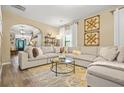 Bright living room showcasing a large sectional sofa, modern table, and arched doorway at 364 Mossycup Dr, Fairburn, GA 30213