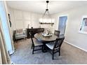 Cozy dining room featuring neutral wall colors and a modern chandelier over a wood table at 3845 Pebble Beach Dr, Atlanta, GA 30349