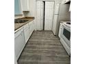 Galley kitchen featuring white appliances, tile countertops, and new flooring at 3609 Ginnis Rd, Atlanta, GA 30331