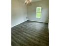 Bright living room with wood-look floors, a window, and a chandelier at 3609 Ginnis Rd, Atlanta, GA 30331