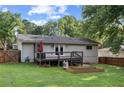 The backyard features a wooden deck, garden beds, and a fully fenced yard surrounded by mature trees at 984 Ridgecrest Se Dr, Smyrna, GA 30080