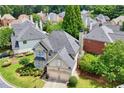 Overhead view of a well-maintained home with lush landscaping, a gray roof, and a two-car garage at 2459 Chestnut Lndg, Atlanta, GA 30360
