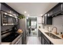 Modern kitchen boasts stainless steel appliances, white subway tile backsplash and dark cabinetry at 5567 Executive Way, Norcross, GA 30071