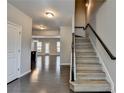 Inviting entryway featuring hardwood floors, staircase, and open view to kitchen and living space at 68 Hardy Water Dr, Lawrenceville, GA 30045