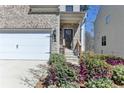 Close-up of front exterior showing garage, entrance, and landscaped flower beds at 68 Hardy Water Dr, Lawrenceville, GA 30045