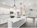 Bright kitchen with white cabinets, quartz countertops, stainless steel appliances, and pendant lighting at 1704 Evenstad Way, Smyrna, GA 30080