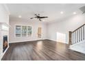Sunlit living room with hardwood floors, fireplace, and staircase with black metal balusters at 1704 Evenstad Way, Smyrna, GA 30080