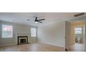 Bright living room features a fireplace, two large windows, and an open doorway to the bathroom at 4131 Carroll St, Covington, GA 30014