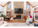 Cozy living room with stone fireplace, wood floors, vaulted ceilings, and plenty of natural light at 5936 Millstone Ln, Stone Mountain, GA 30087