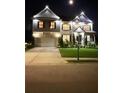 Elegant two-story home illuminated at night, showcasing a manicured lawn and charming architectural details at 1730 Dahlia Dr, Cumming, GA 30040