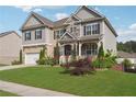 Beautiful two-story home with a well-maintained lawn, stone details, and a welcoming front porch at 1730 Dahlia Dr, Cumming, GA 30040