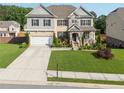 Attractive two-story home boasting a well-kept lawn, stone accents, and a convenient two-car garage at 1730 Dahlia Dr, Cumming, GA 30040
