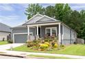 Exterior of a house with front porch, colorful landscaping, and a well-maintained lawn at 3026 Towne Mill Ave, Canton, GA 30114