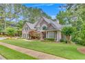 Charming two-story home with lush lawn, manicured landscaping and mature trees at 407 Amber Ln, Woodstock, GA 30189