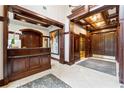 Condo lobby featuring wood trim, tile floors, a reception desk, artwork, and elevators at 77 Peachtree Ne Pl # 101, Atlanta, GA 30309
