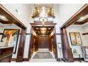 Condo lobby featuring wood trim, tile floors, a reception desk, artwork, and elevators at 77 Peachtree Ne Pl # 101, Atlanta, GA 30309