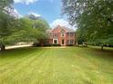 Traditional two-story brick home surrounded by mature trees and a spacious front yard at 110 Wyngate Way, Fayetteville, GA 30215