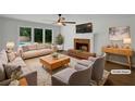 Staged living room featuring a cozy fireplace, large windows, and modern furnishings at 110 Wyngate Way, Fayetteville, GA 30215