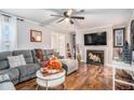 Open-concept living area with fireplace, hardwood floors, grey sectional, and bright decor at 46 Le Parc Fontaine, Lithonia, GA 30038