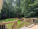 A wooden deck overlooks a lush, green backyard surrounded by mature trees at 328 West Ln, Woodstock, GA 30188