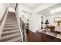 Elegant entryway featuring hardwood floors, staircase, and dining room with wainscoting at 3291 Meadow Lily Ct, Buford, GA 30519