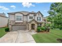Charming two-story home featuring a stone facade, well-manicured lawn, and an attached two-car garage at 3291 Meadow Lily Ct, Buford, GA 30519
