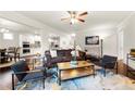 Open concept living room with hardwood floors, ceiling fan, and view to the kitchen at 3291 Meadow Lily Ct, Buford, GA 30519
