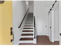 Bright entryway featuring hardwood floors, a wooden staircase, and contemporary white doors with black hardware at 415 Gartrell Se St # 15, Atlanta, GA 30312