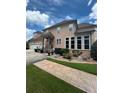 Side view of a home featuring a three-car garage, manicured lawn, and stamped concrete pathway at 716 Bethpage Dr, Mcdonough, GA 30253