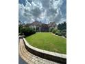Beautifully landscaped front yard with mature trees and shrubs leading up to a grand home at 716 Bethpage Dr, Mcdonough, GA 30253