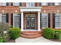Charming front entrance with brick steps, columns, and a decorative glass door at 871 Windsor Creek Dr, Grayson, GA 30017