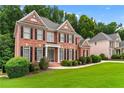 Beautiful red brick home with black shutters and landscaped front yard at 871 Windsor Creek Dr, Grayson, GA 30017