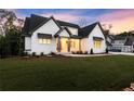 Beautiful new construction features a well-manicured lawn and bright white painted brick exterior with gray trim at 6750 Pannell Rd, Buford, GA 30518