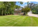 Charming two-story home featuring a covered front porch, brick accents, and a well-manicured lawn at 654 Cannon Rd, Sharpsburg, GA 30277