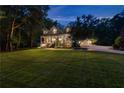 Beautiful two-story home at dusk, showcasing a covered front porch and lush, green landscaping at 654 Cannon Rd, Sharpsburg, GA 30277