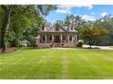 Attractive two-story home with a covered porch, brick accents, and a large, well-maintained lawn at 654 Cannon Rd, Sharpsburg, GA 30277