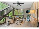 Relaxing screened-in porch features a ceiling fan, comfortable wicker furniture, and views of the lush greenery at 1315 Woodland Trce, Cumming, GA 30041