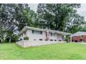 A charming single-story home with well-maintained lawn and brick foundation, and carport at 1982 Yucca Dr, Decatur, GA 30032
