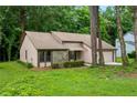 Inviting single-story home with light beige siding, a stone facade, and surrounded by mature trees at 4818 Terrace Green Trce, Stone Mountain, GA 30088
