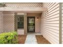 Close-up of the front door with a security screen and light beige siding, framed by green bushes at 4818 Terrace Green Trce, Stone Mountain, GA 30088