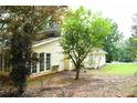 Rear exterior featuring sunroom, large windows, and surrounding greenery at 9130 Charlton Pl, Douglasville, GA 30135