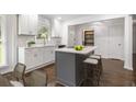Well-lit updated kitchen with grey island, modern white cabinets, stainless appliances, and hardwood flooring at 2358 Armand Ne Rd, Atlanta, GA 30324