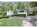 Charming single-story home with white painted brick, manicured landscaping, and covered parking at 2800 Mornington Nw Dr, Atlanta, GA 30327