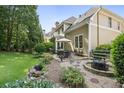 An inviting backyard with a stone patio, complete with a fire pit and seating area, surrounded by lush landscaping at 4874 Registry Nw Ln, Kennesaw, GA 30152