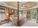 Comfortable main bedroom with a four-poster bed, tray ceiling, and access to a private balcony at 4874 Registry Nw Ln, Kennesaw, GA 30152