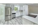 Beautiful kitchen featuring stainless steel appliances, white cabinetry, stone countertops, and modern flooring at 2489 Smith Ave, Marietta, GA 30064